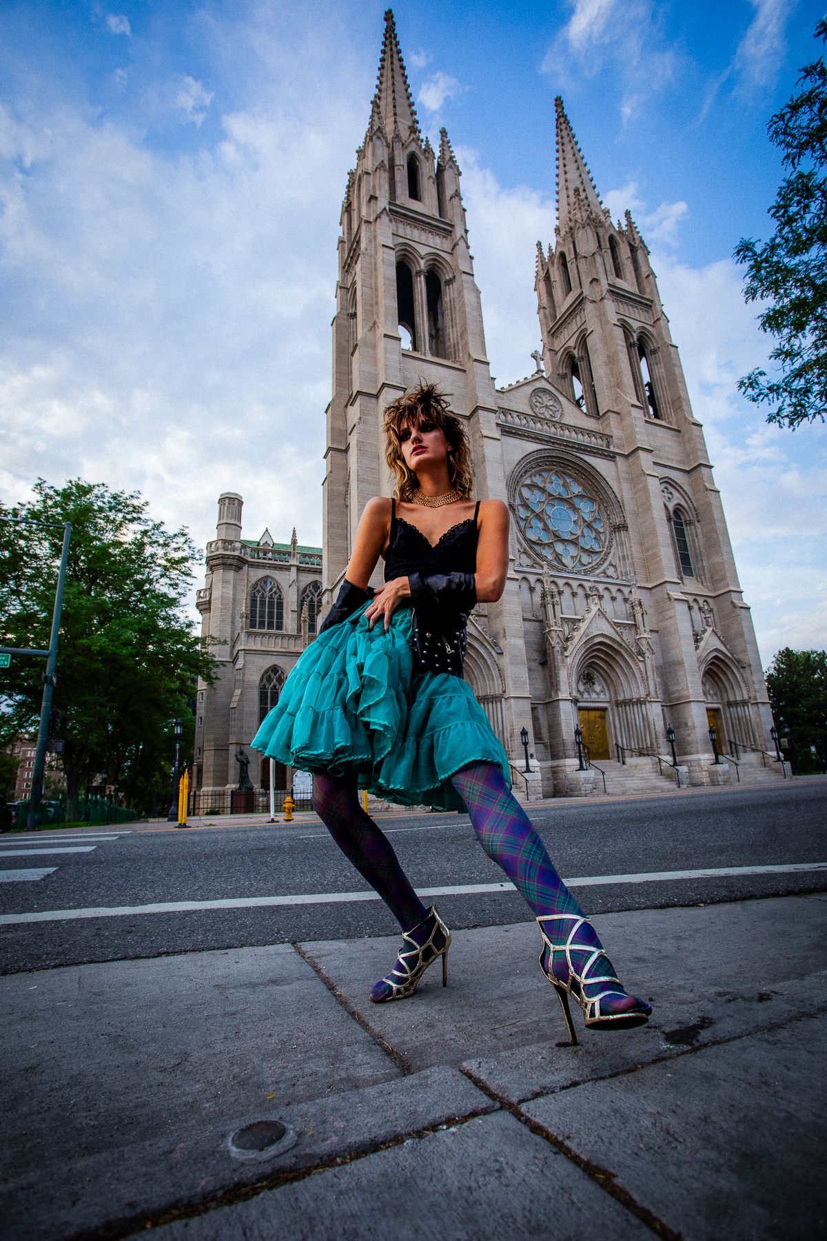 Dramatic fashion shoot featuring teal skirt against backdrop of gothic cathedral spires.