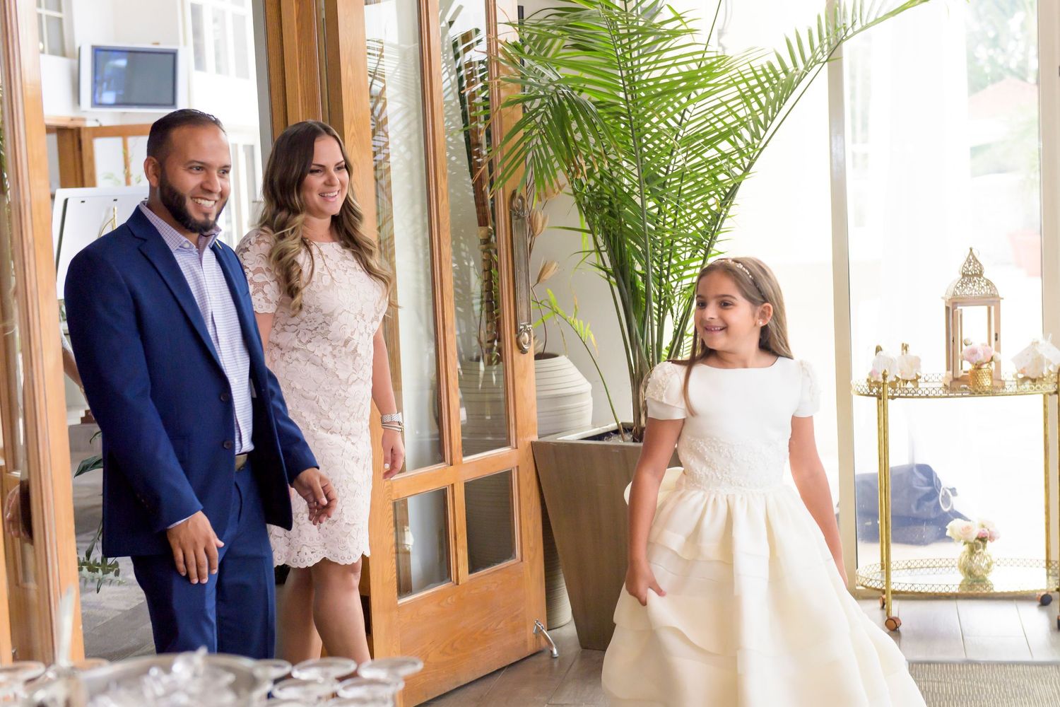 Wedding celebration scene with elegant indoor decor and potted palm plant.