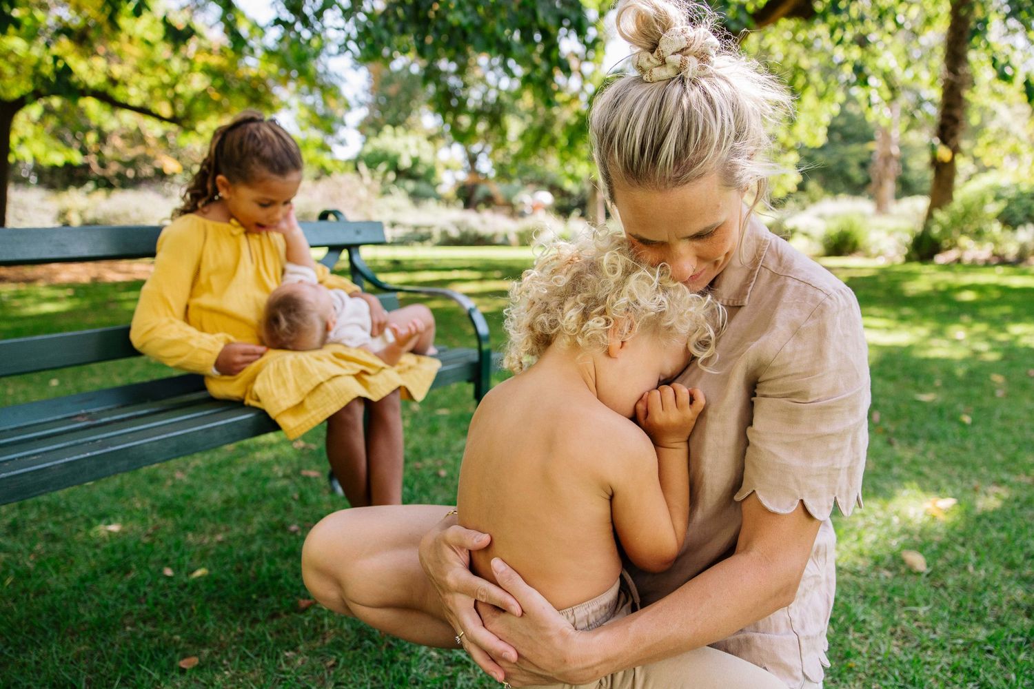 A Mother and her three kids all in a beautiful still moment of calm. A photo full of love.