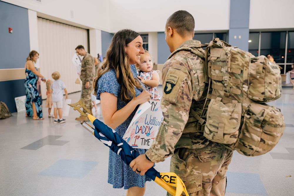 Military reunion scene showing emotional greeting between soldier and family members.