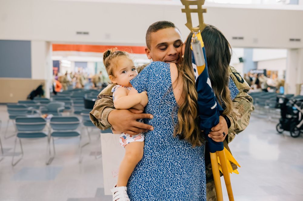Touching family reunion moment in airport terminal with soldier in uniform.