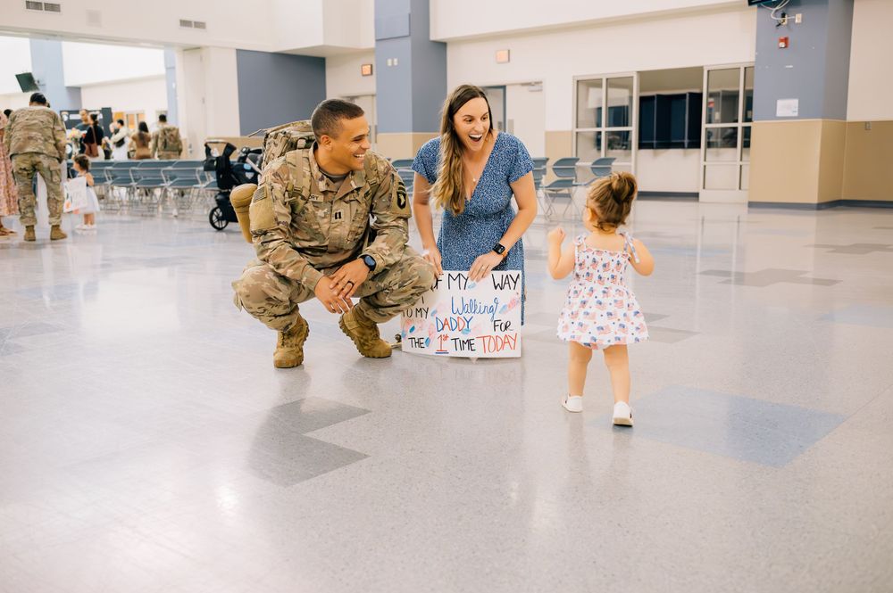 Heartwarming military reunion with family in institutional building hallway.