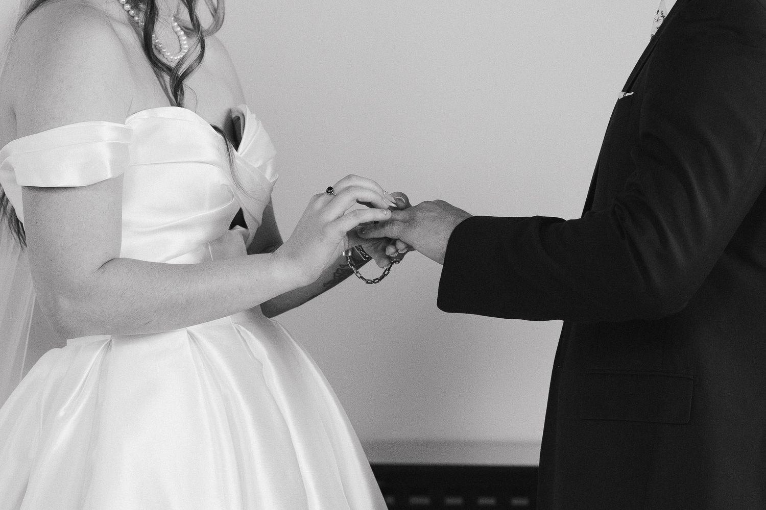 A cropped in image of a couple exchanging rings in black and white during their ceremony at Hauser Hall in Heidelberg
