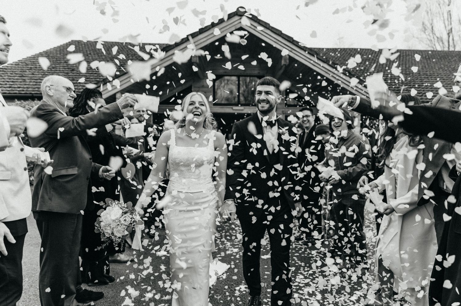 Silhouettes of people dancing against backlit white curtains at a wedding reception.