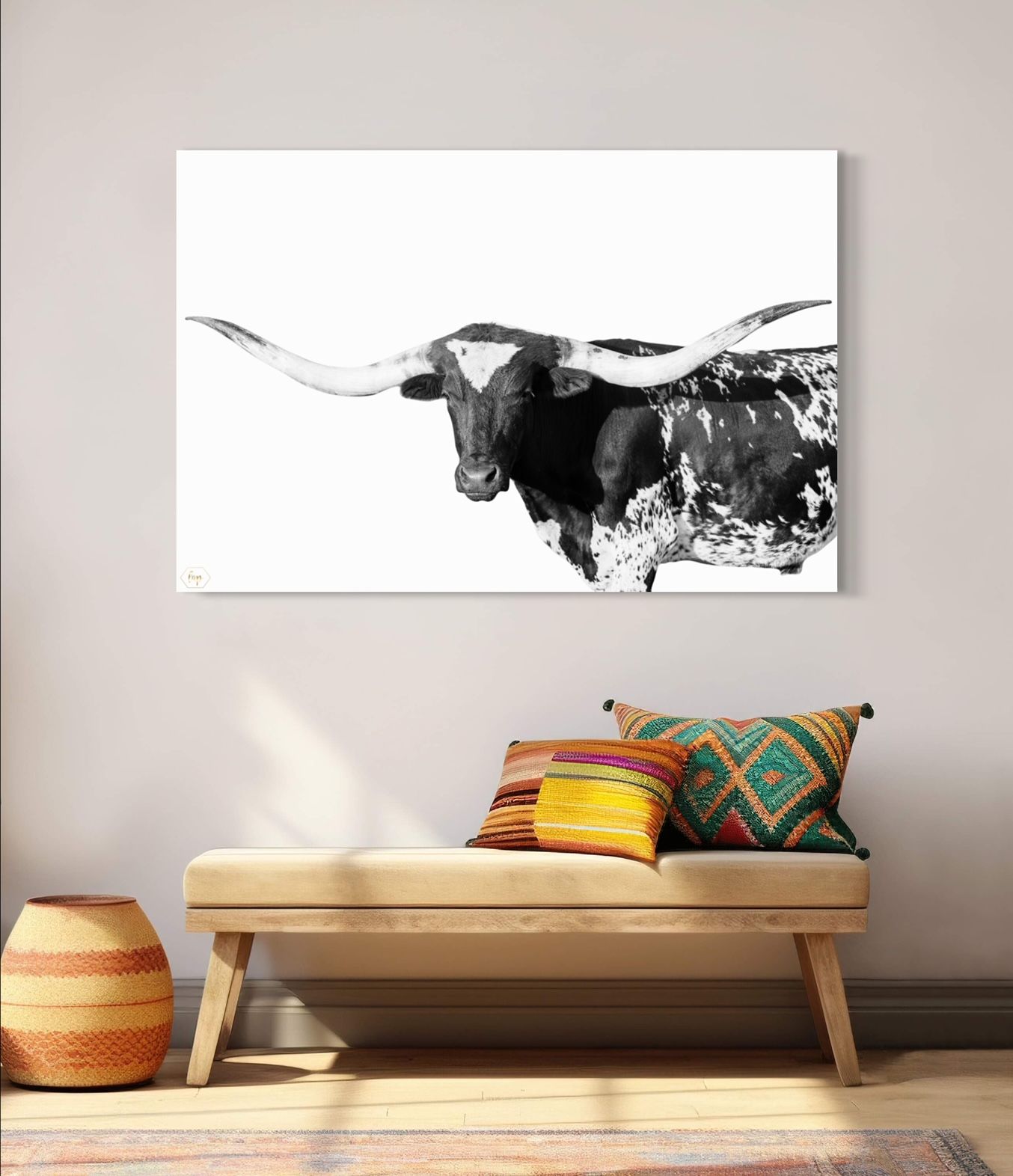 Black and white longhorn bull portrait canvas displayed above modern bench with decorative pillows.