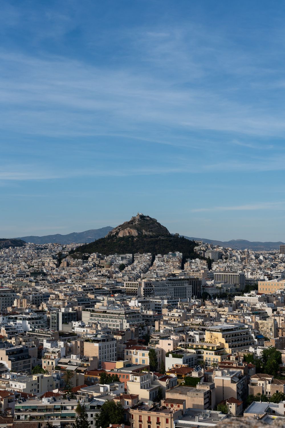 Aerial view of Athens cityscape with Mount Lycabettus rising prominently in the center.