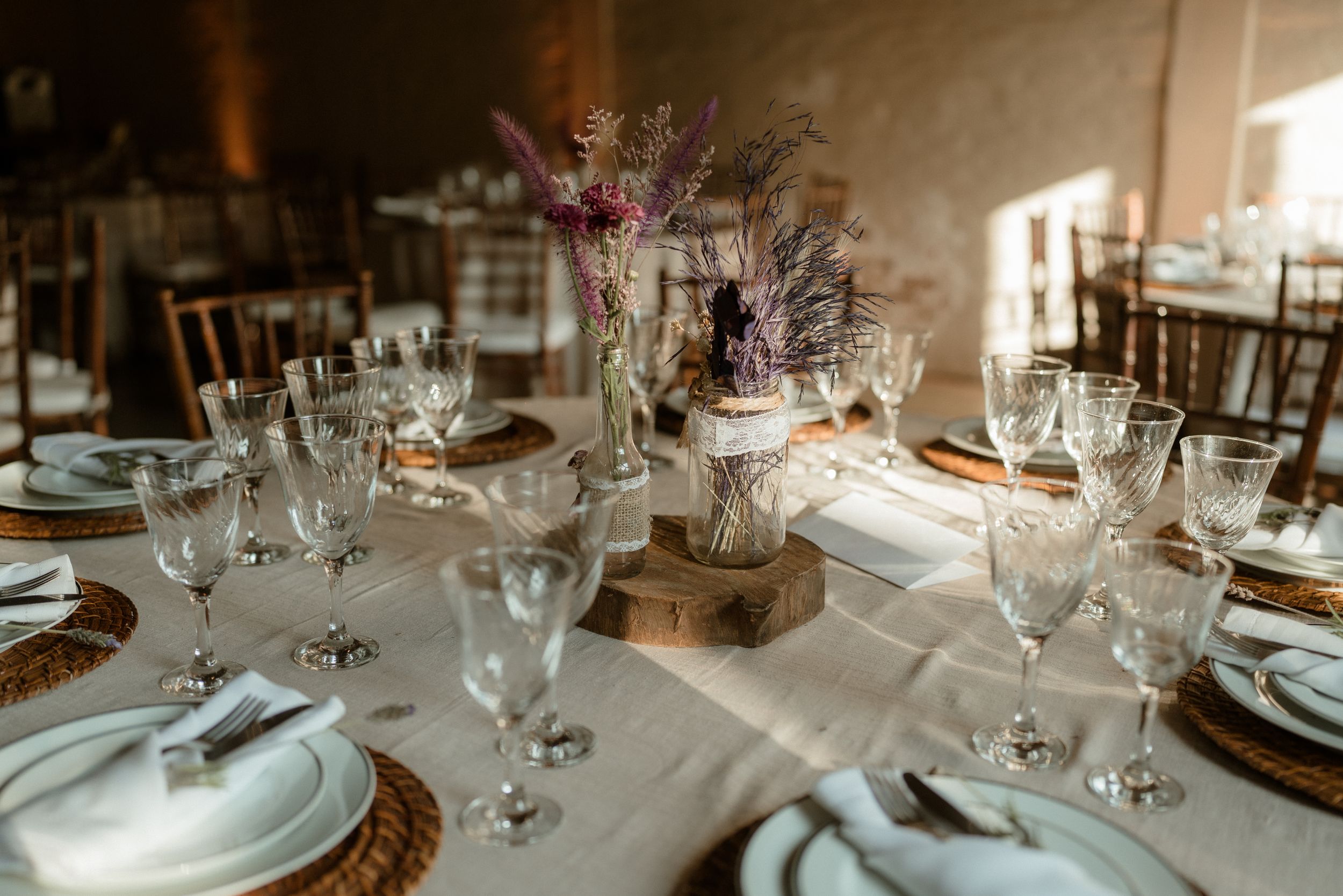 White table settings and glassware arranged for an elegant wedding reception.