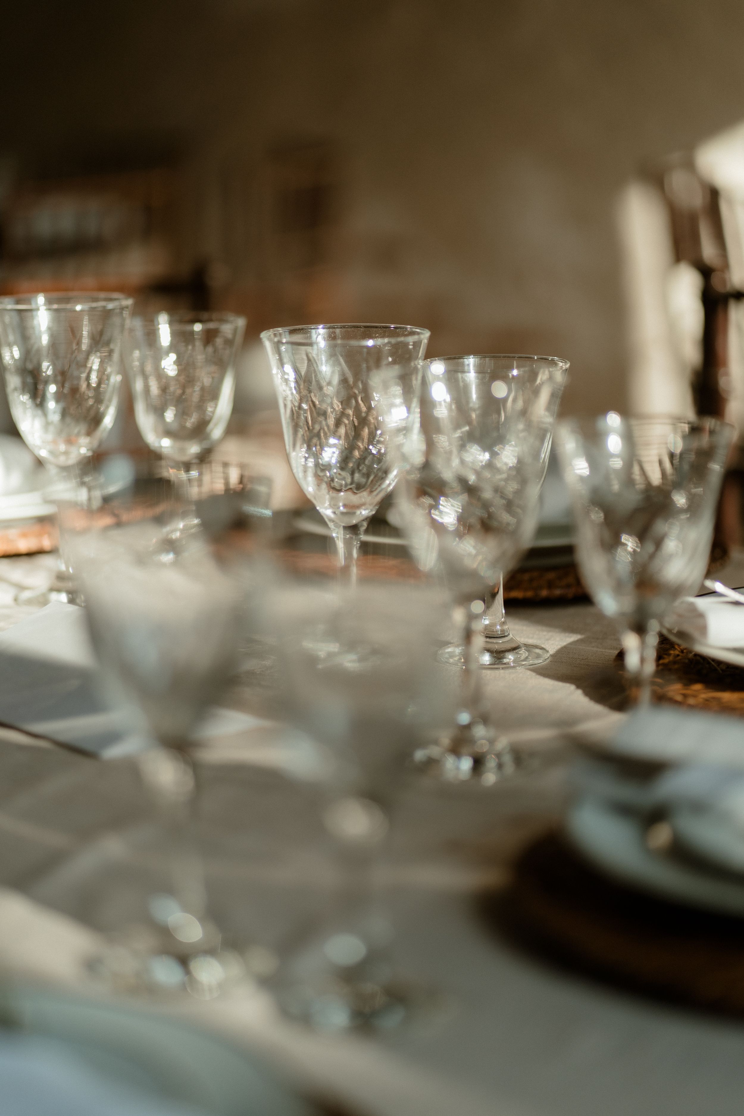 Crystal wine glasses arranged on an elegant table setting with soft focus.