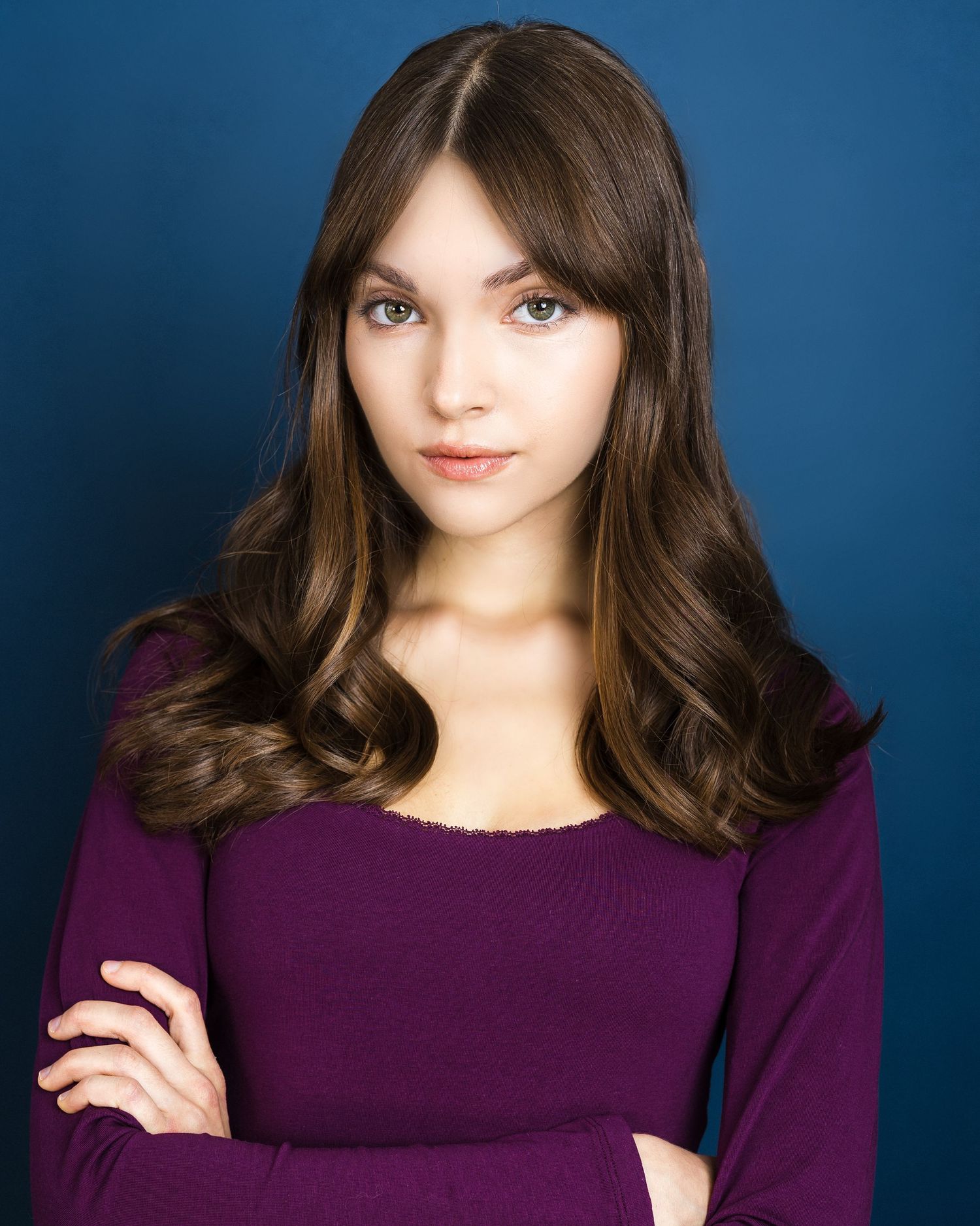 A series of studio portraits against a blue background featuring a person in a purple sweater with dark hair.