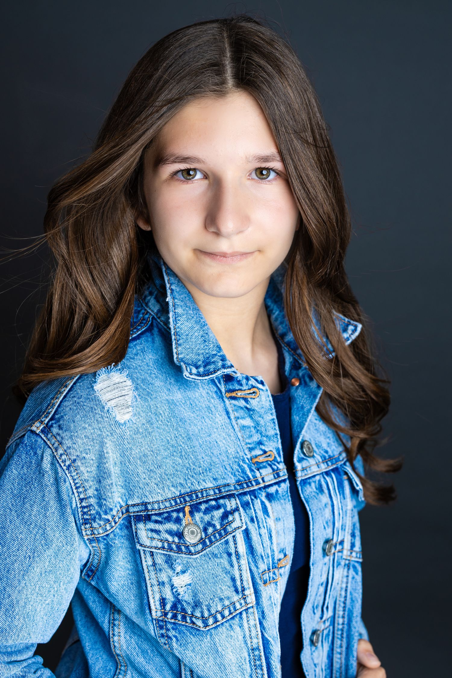 A series of headshots showing someone wearing a light blue denim jacket against a dark background.
