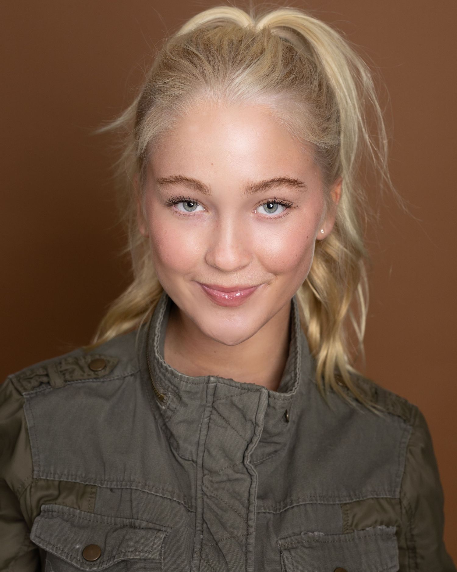 A series of six close-up photos showing someone's expressive faces in a green military-style jacket against a brown backdrop.