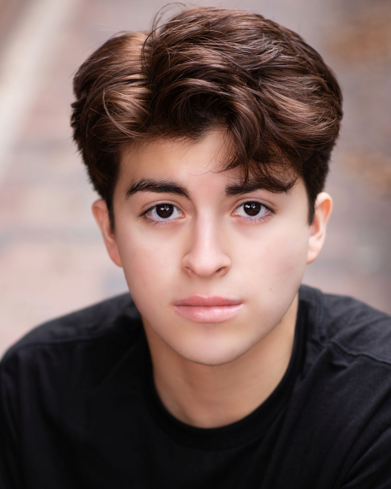 Portrait of a young person in black attire against a soft focused background.
