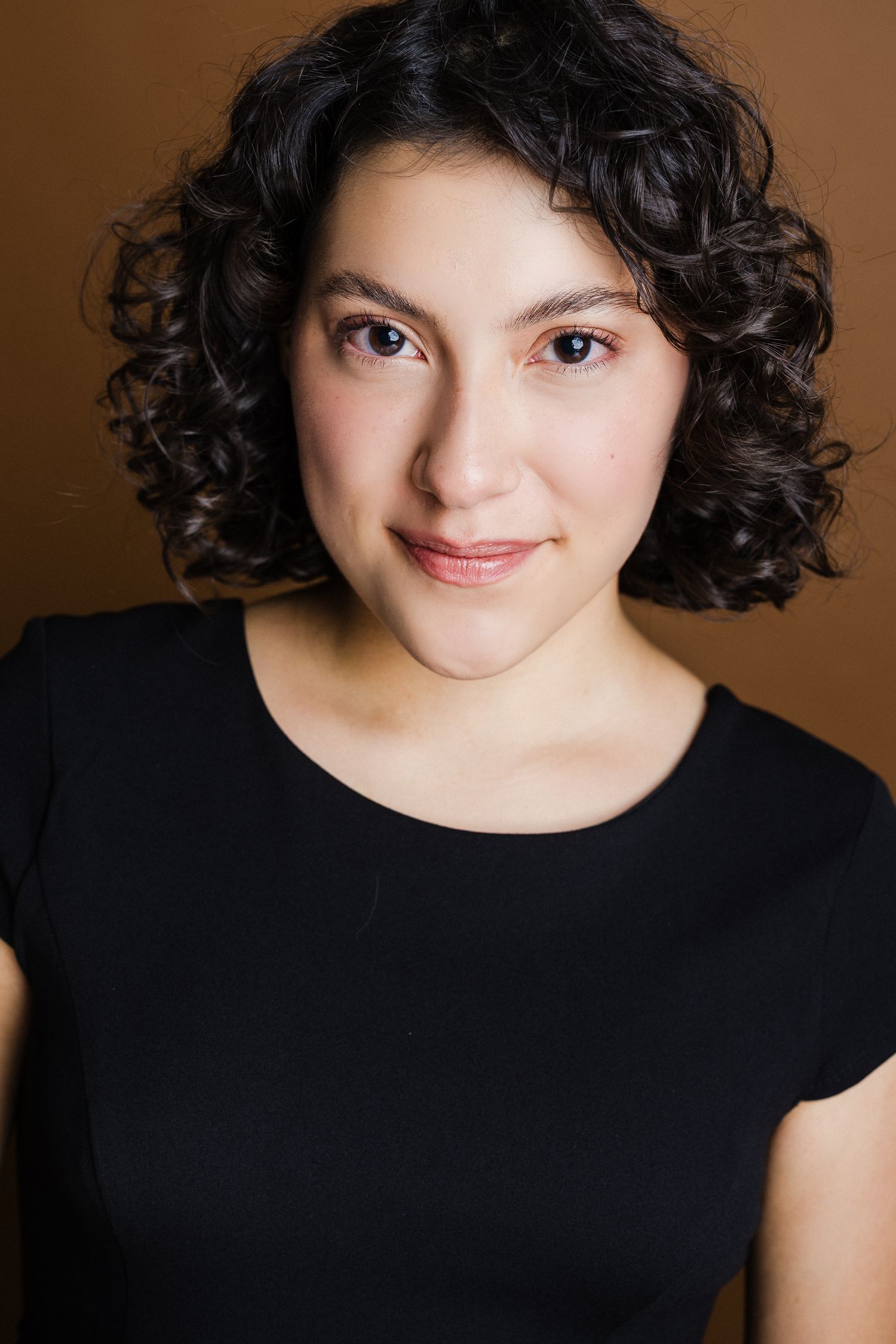 A sequence of headshots shows someone with dark curly hair wearing a black top against a brown background posing expressively.