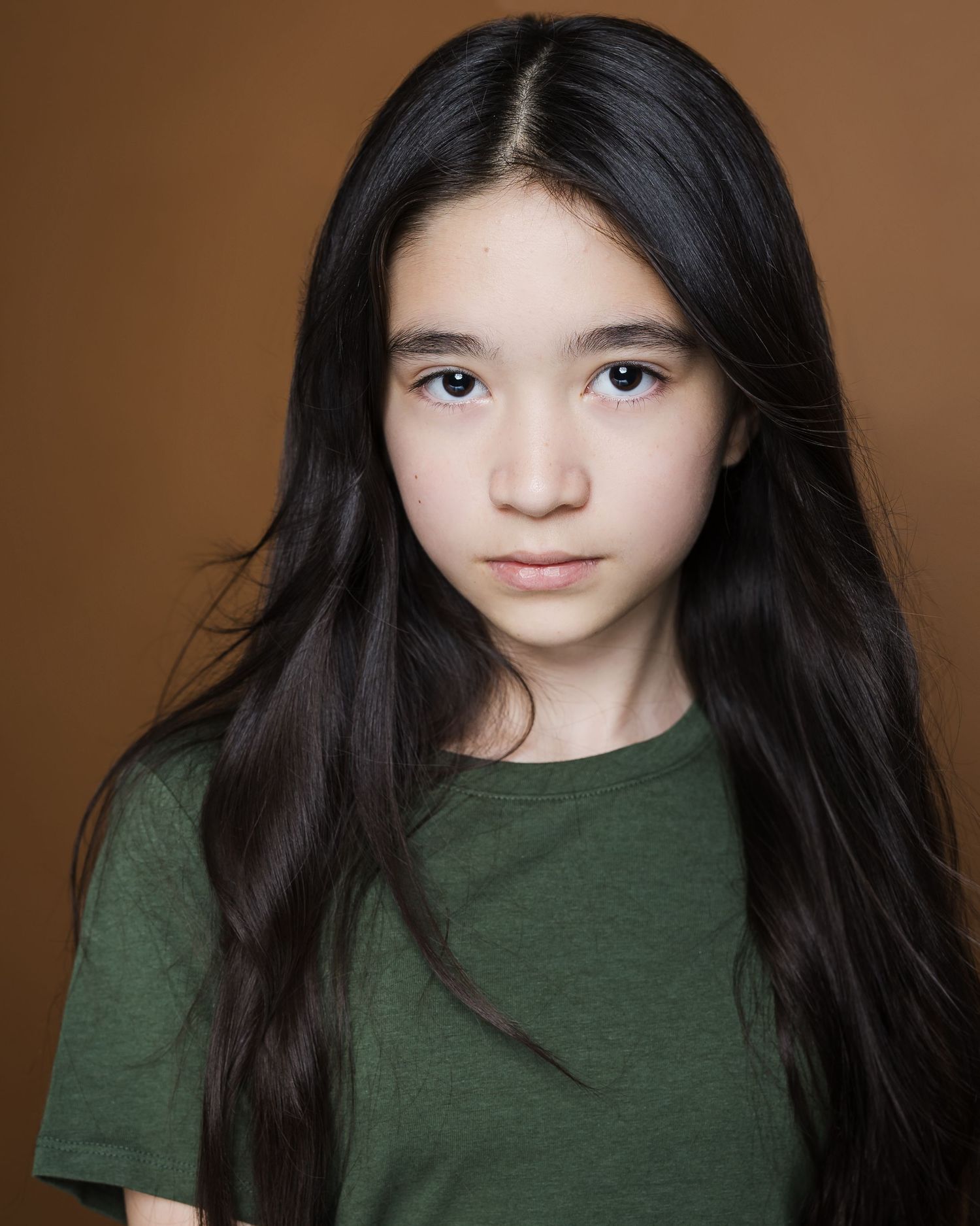 A photo series showing expressive poses with dark hair against a brown background wearing a green top.
