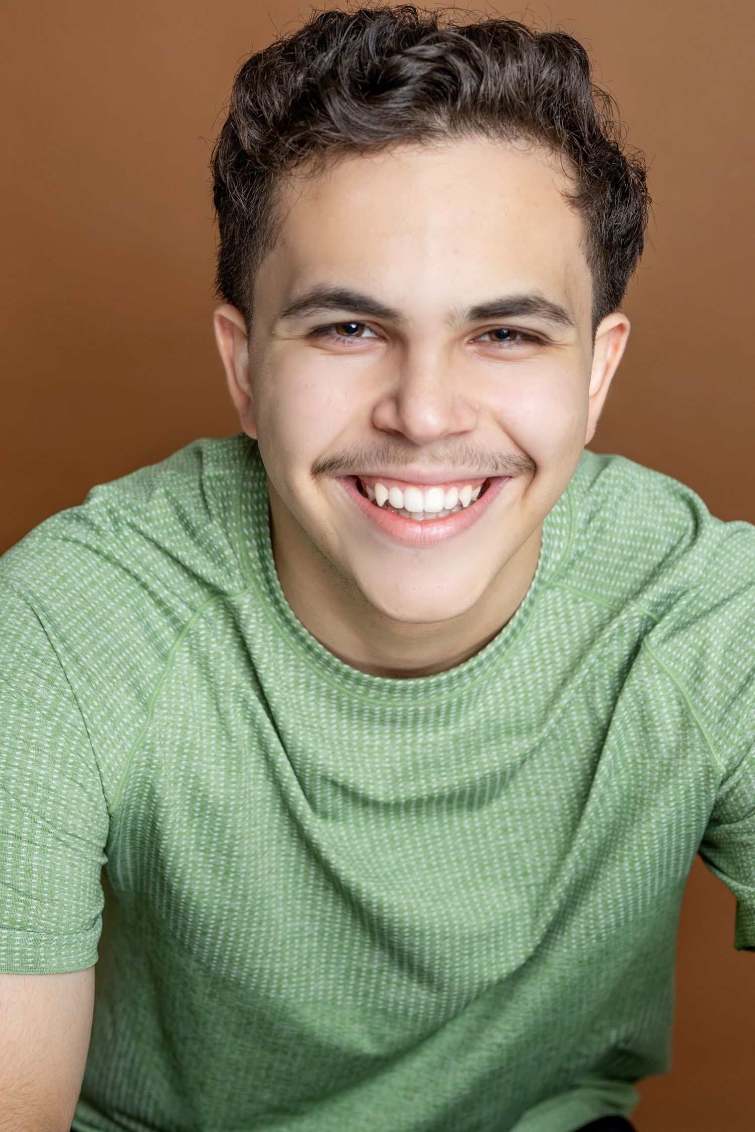 A series of smiling portraits showing a person in a mint green sweater against a brown background.