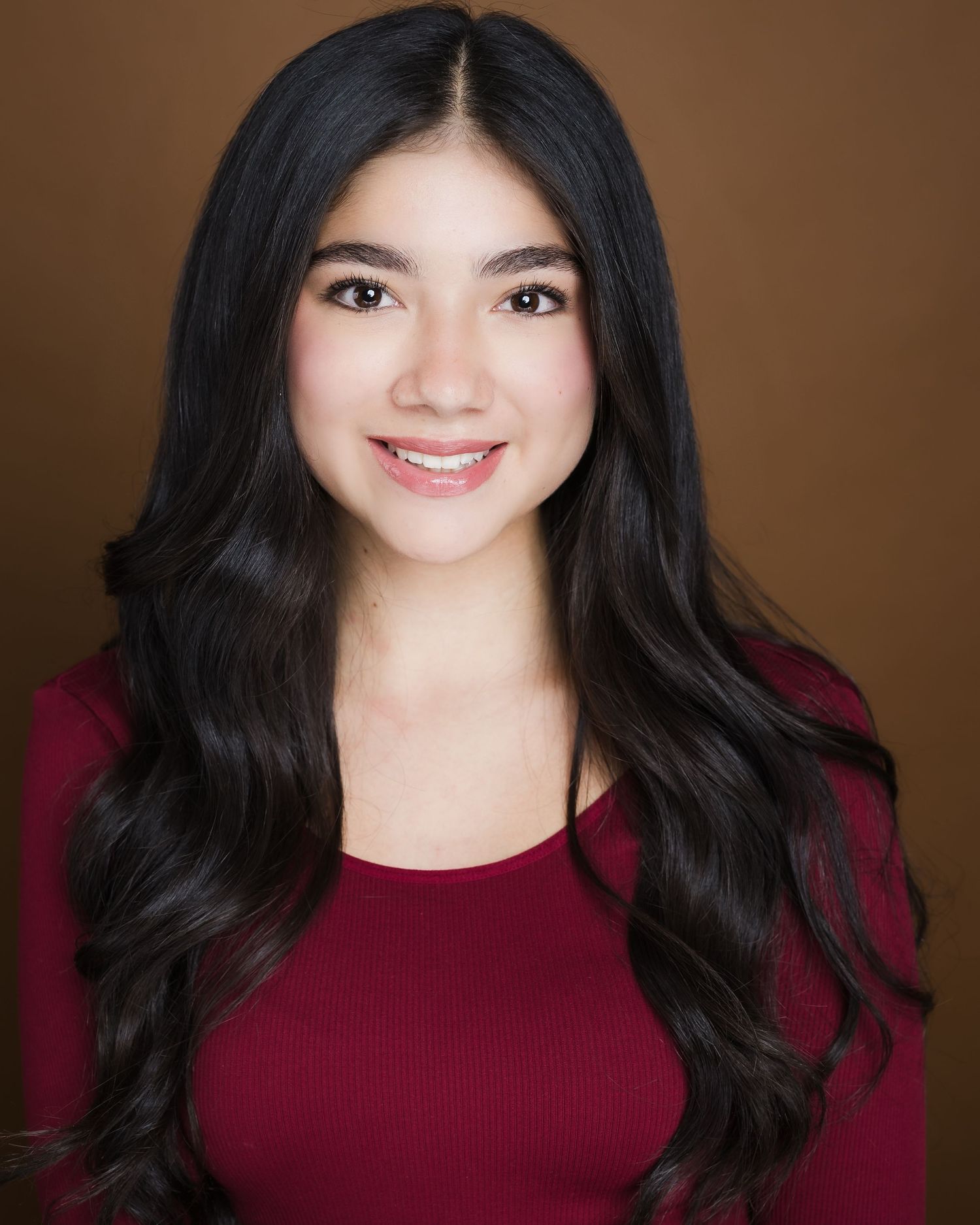 A woman in a burgundy sweater appears in a professional headshot series showing various expressions against a dark background.