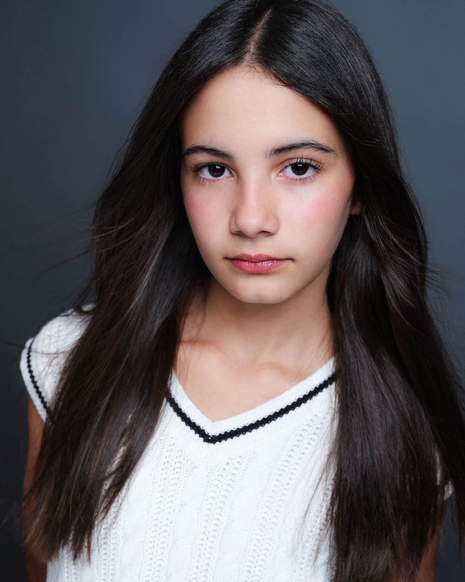 Studio portrait series in white sweater against dark background showing different poses and expressions.