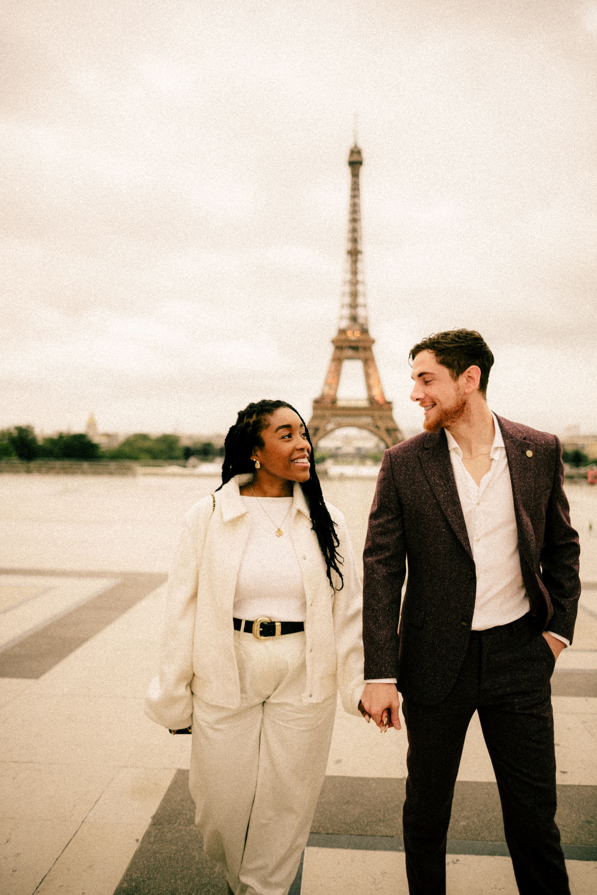 A romantic couple shares a moment together in front of the Eiffel Tower.