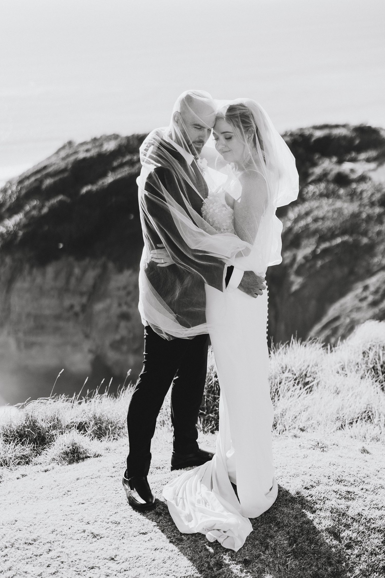 bride and groom at Muriwai beach after their wedding at Tui Hill wedding venue. Auckland Wedding Photographer