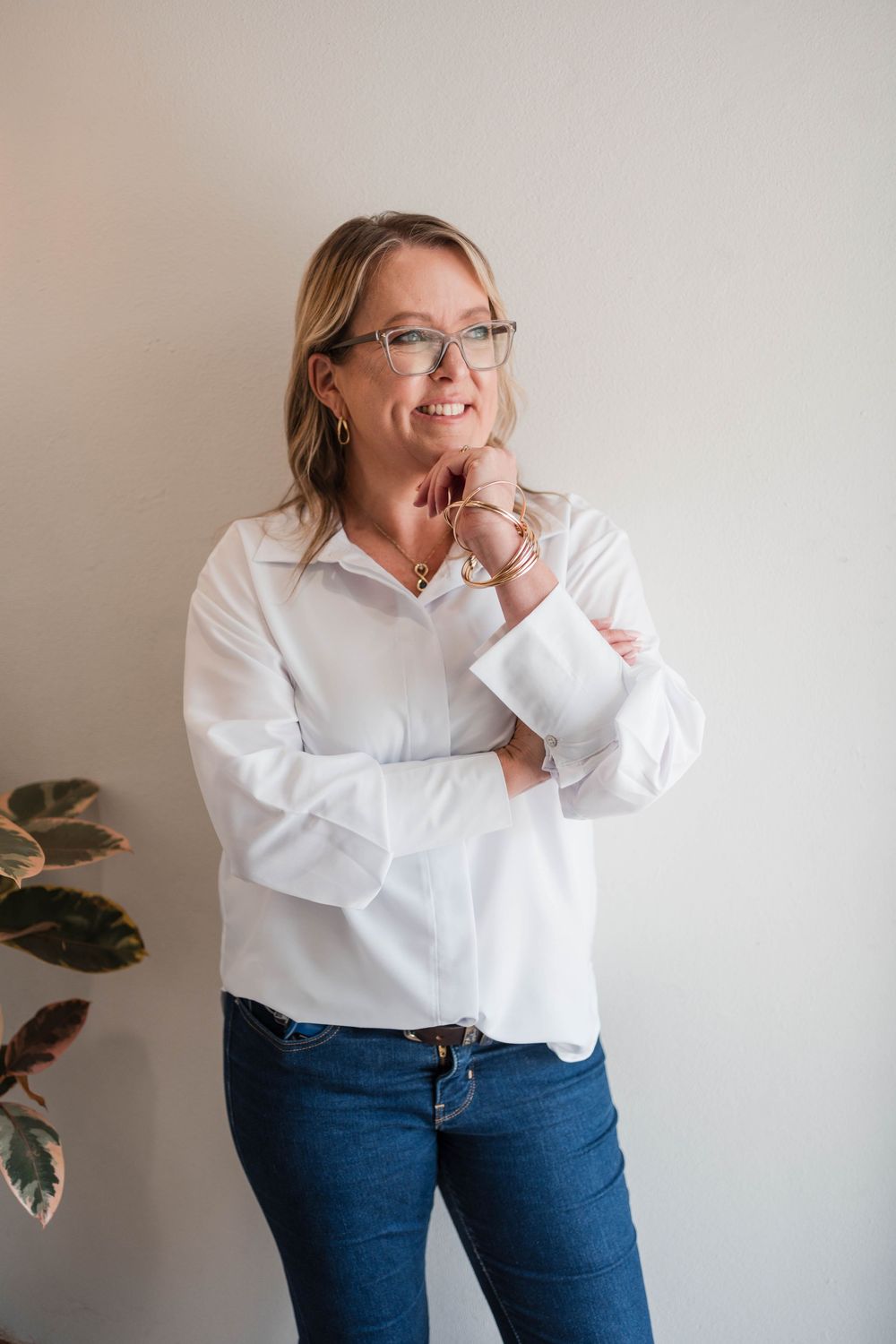 A series of casual portraits showing a person in a white button-down shirt and jeans posing against a light wall.