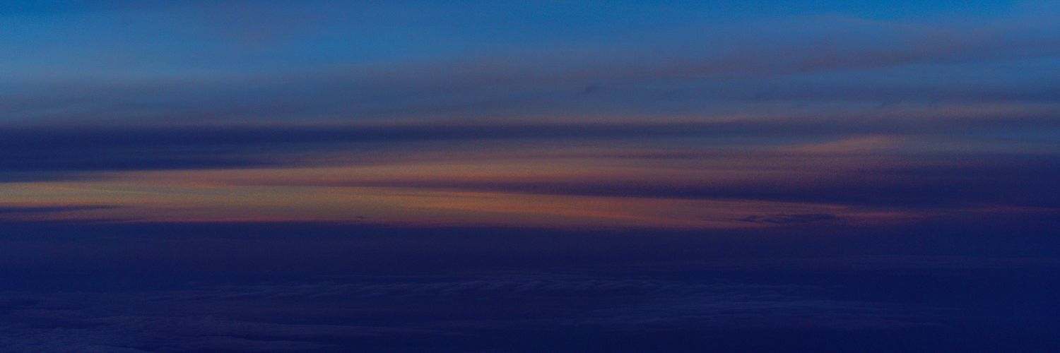 Minimalist panoramic view of a dark blue twilight sky with subtle color gradients.