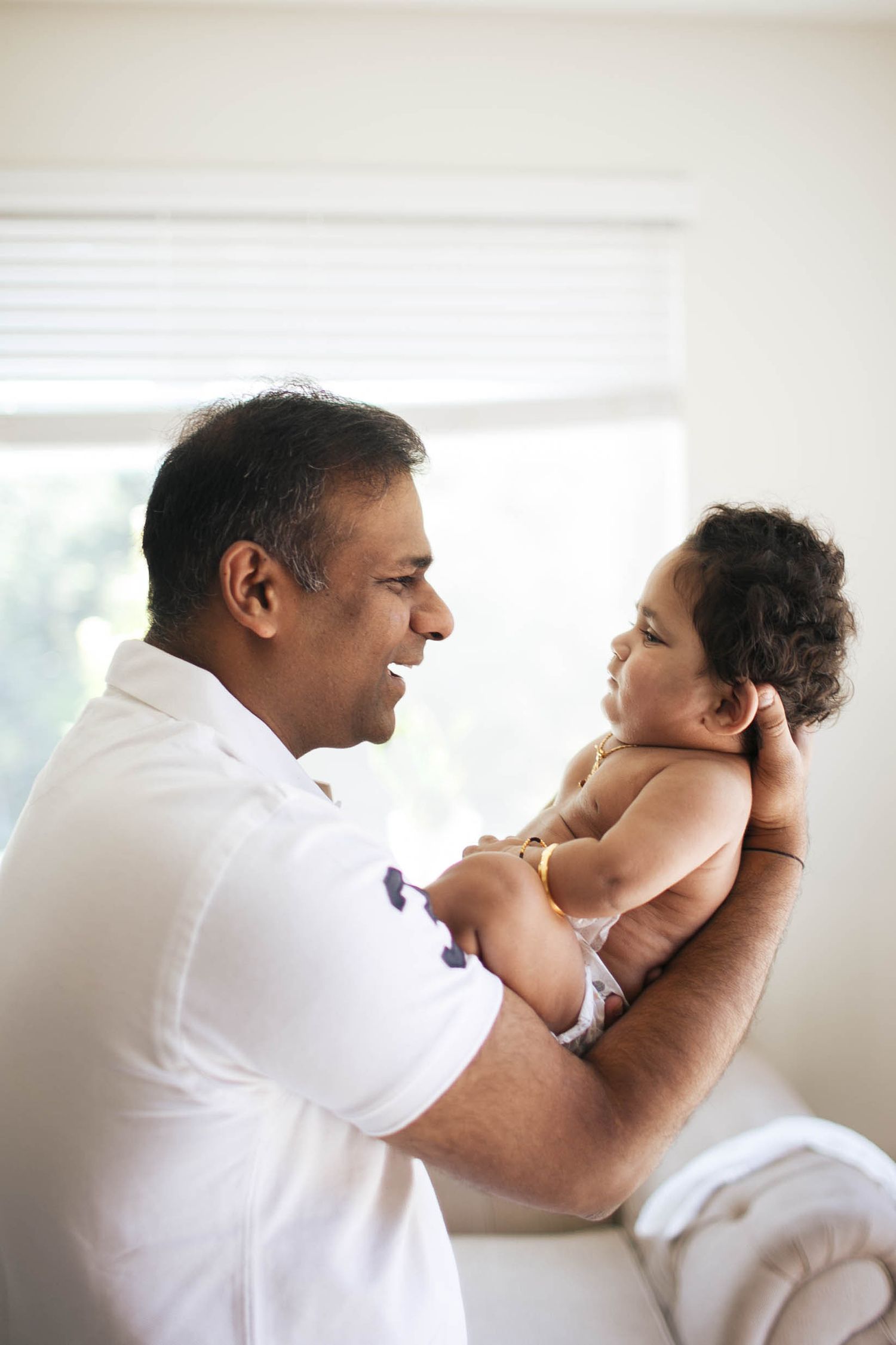 Seattle in-home photographer: a father holds his 1-year old son at an in-home family photo session