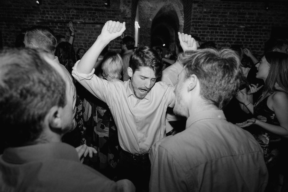 Energetic crowd dancing and celebrating at a lively party in black and white.