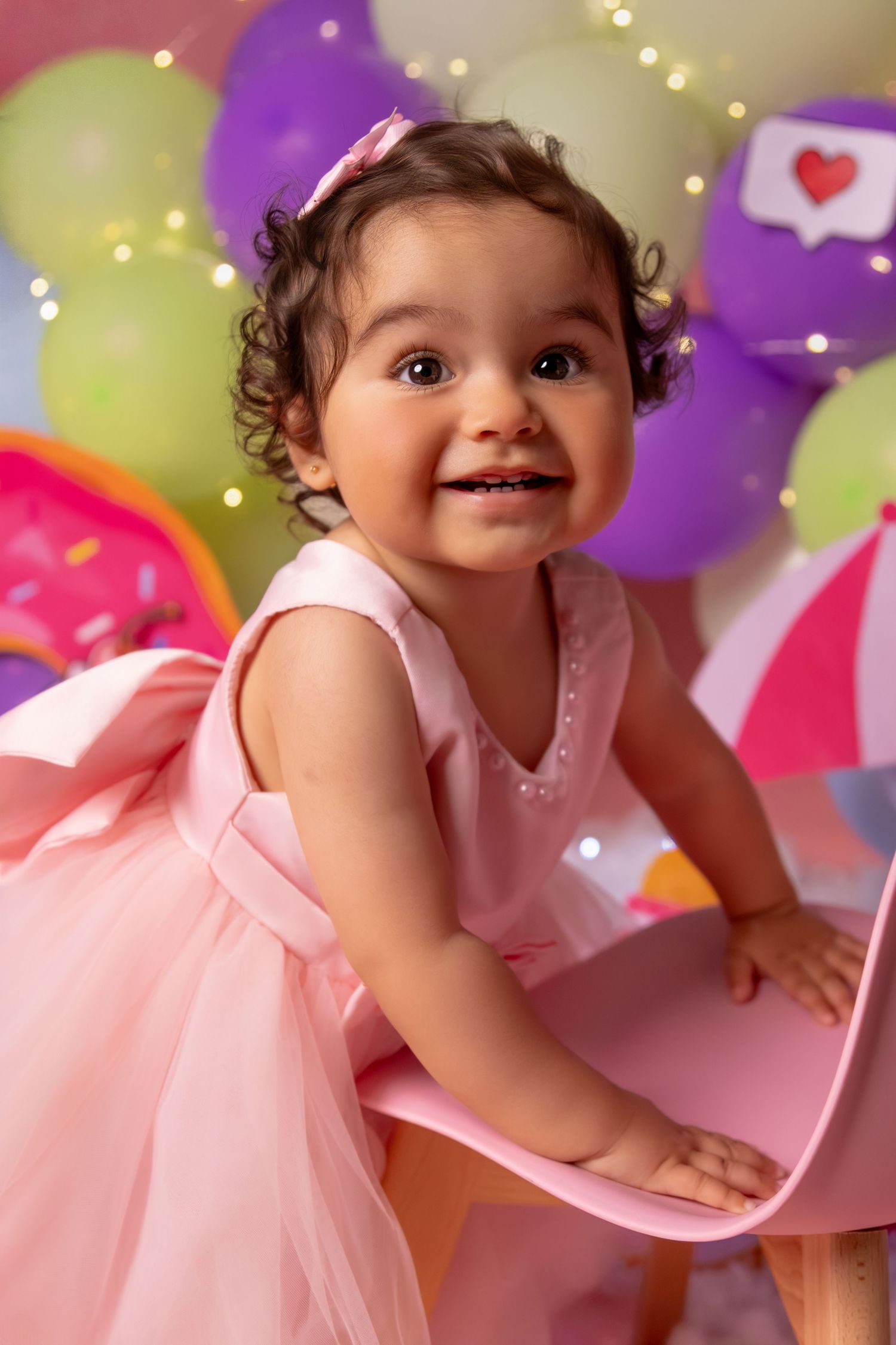 Pink and purple balloon decorated photo session with sparkly lighting effects.