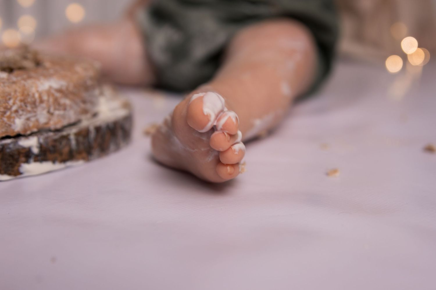 Close-up of tiny feet with cake crumbs during first birthday celebration.