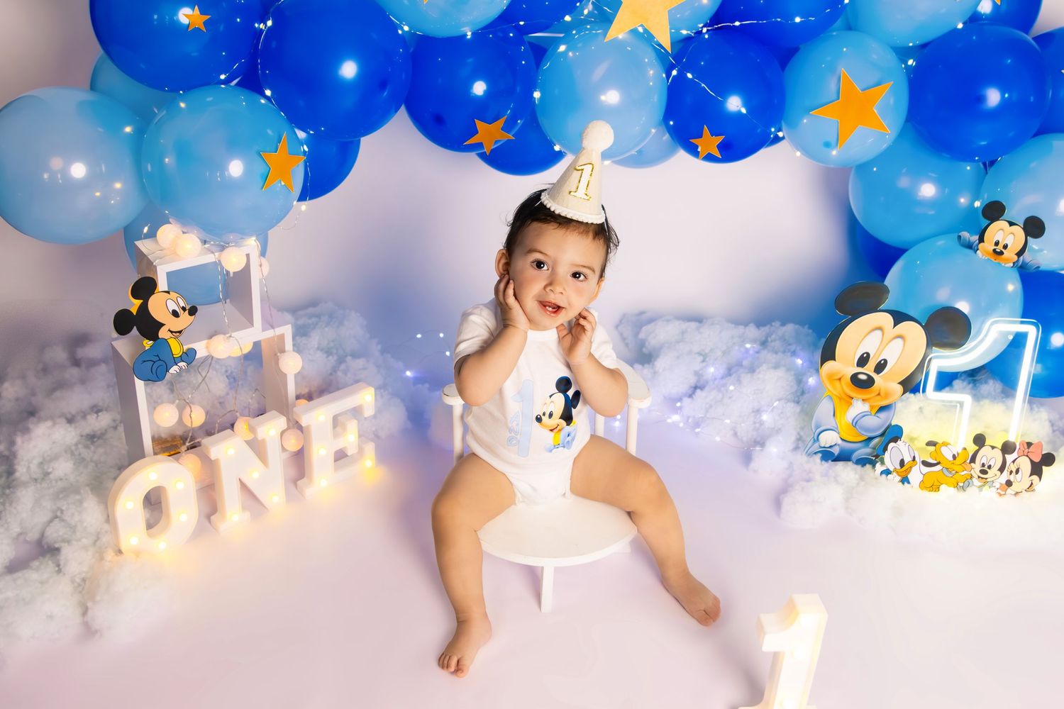 First birthday celebration with Mickey Mouse theme and blue balloon decorations.