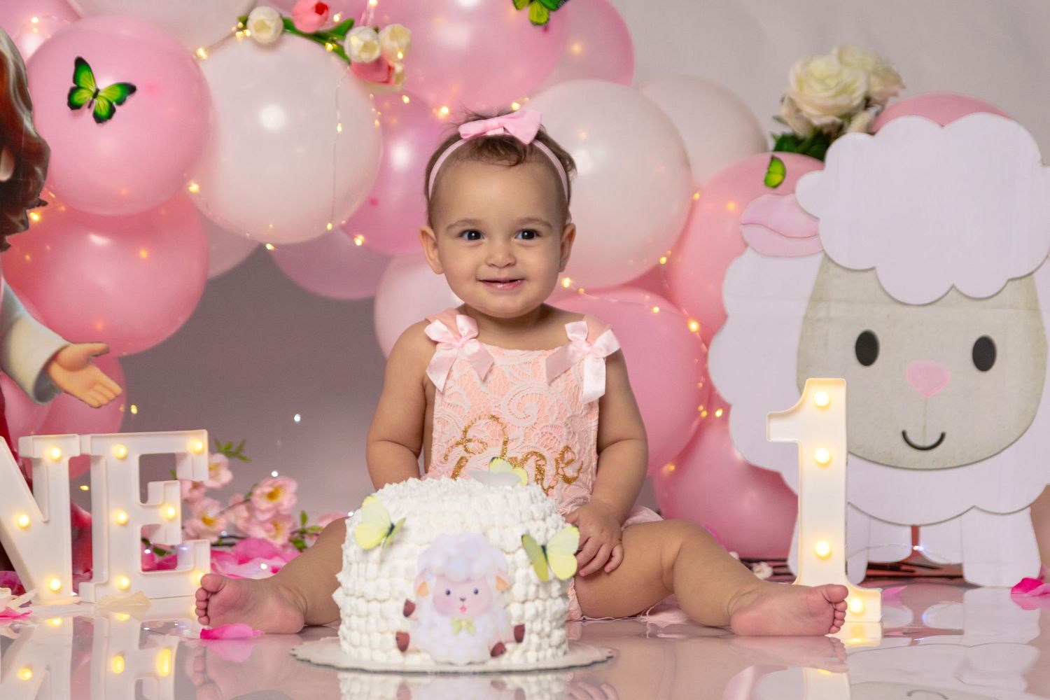 First birthday celebration setup with cake, balloons, and whimsical decorations.
