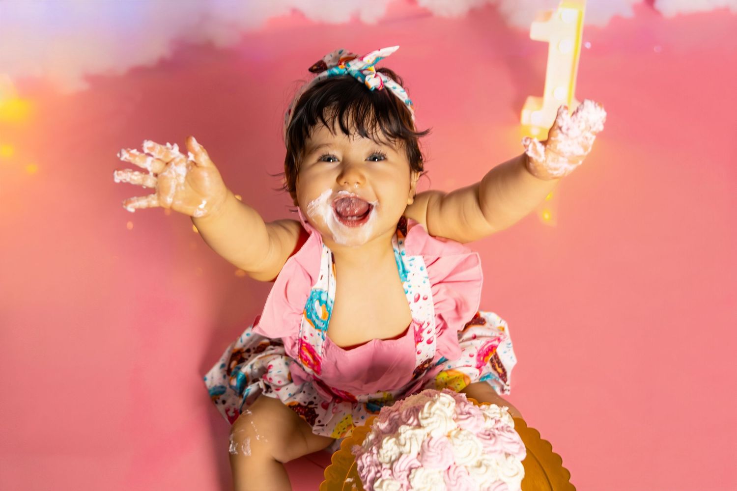 Pink backdrop birthday celebration scene with festive decorations.