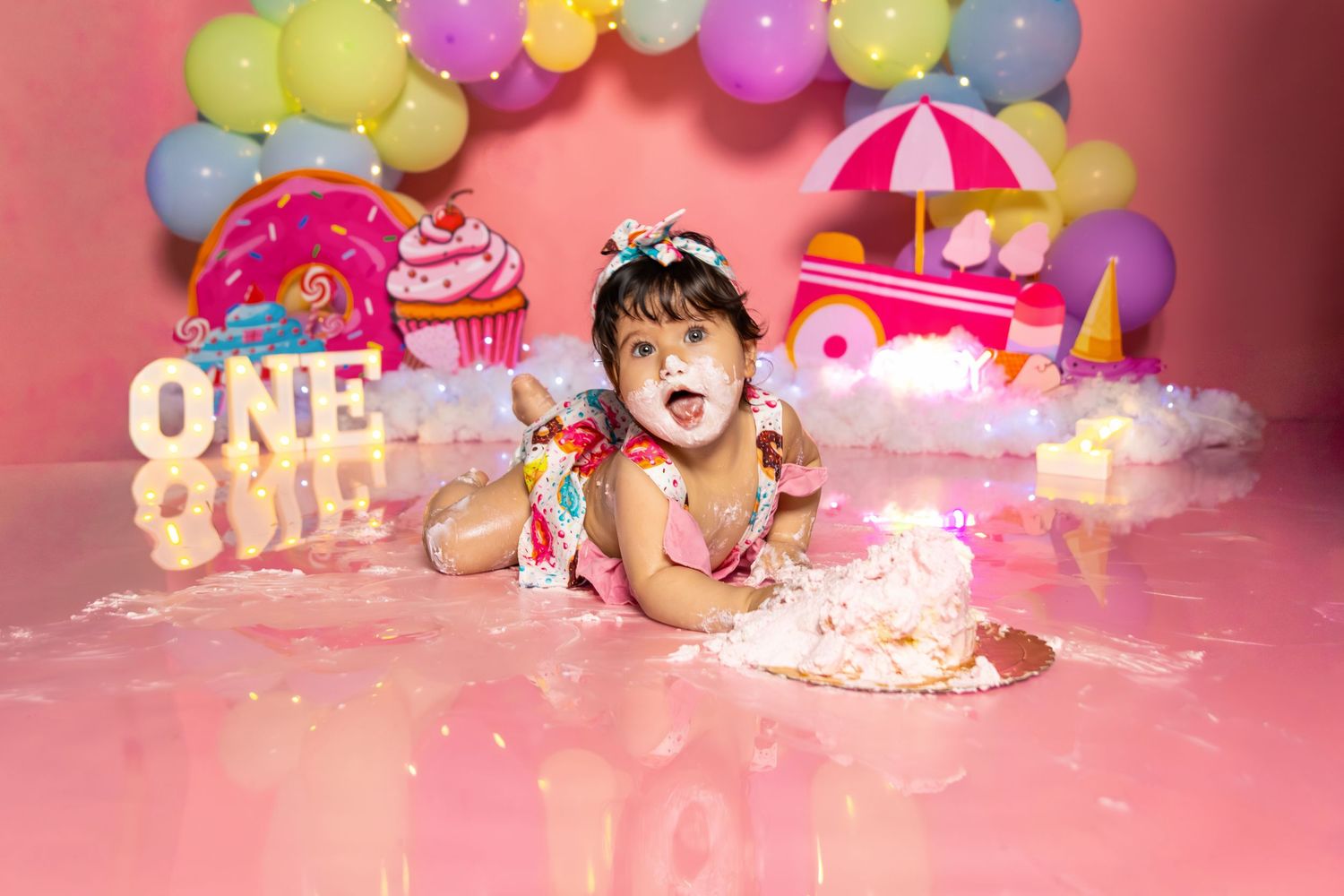 First birthday setup with colorful balloons and pink decorations.