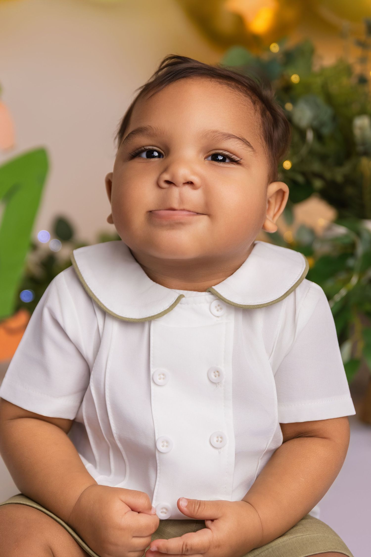 Baby wearing white peter pan collar shirt during professional photo session.