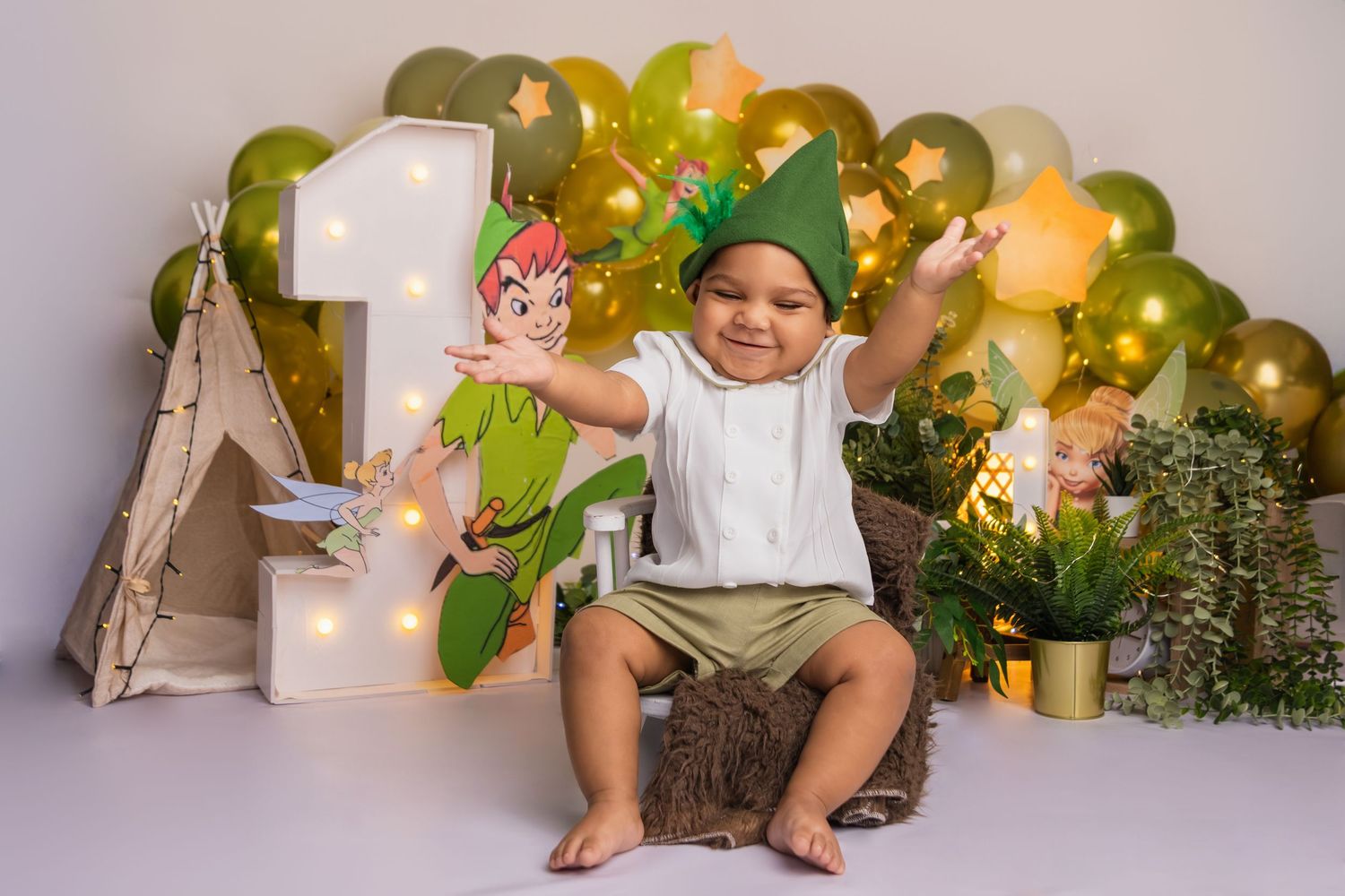 Professional photo setup with green and gold balloons, plants and wooden accents.