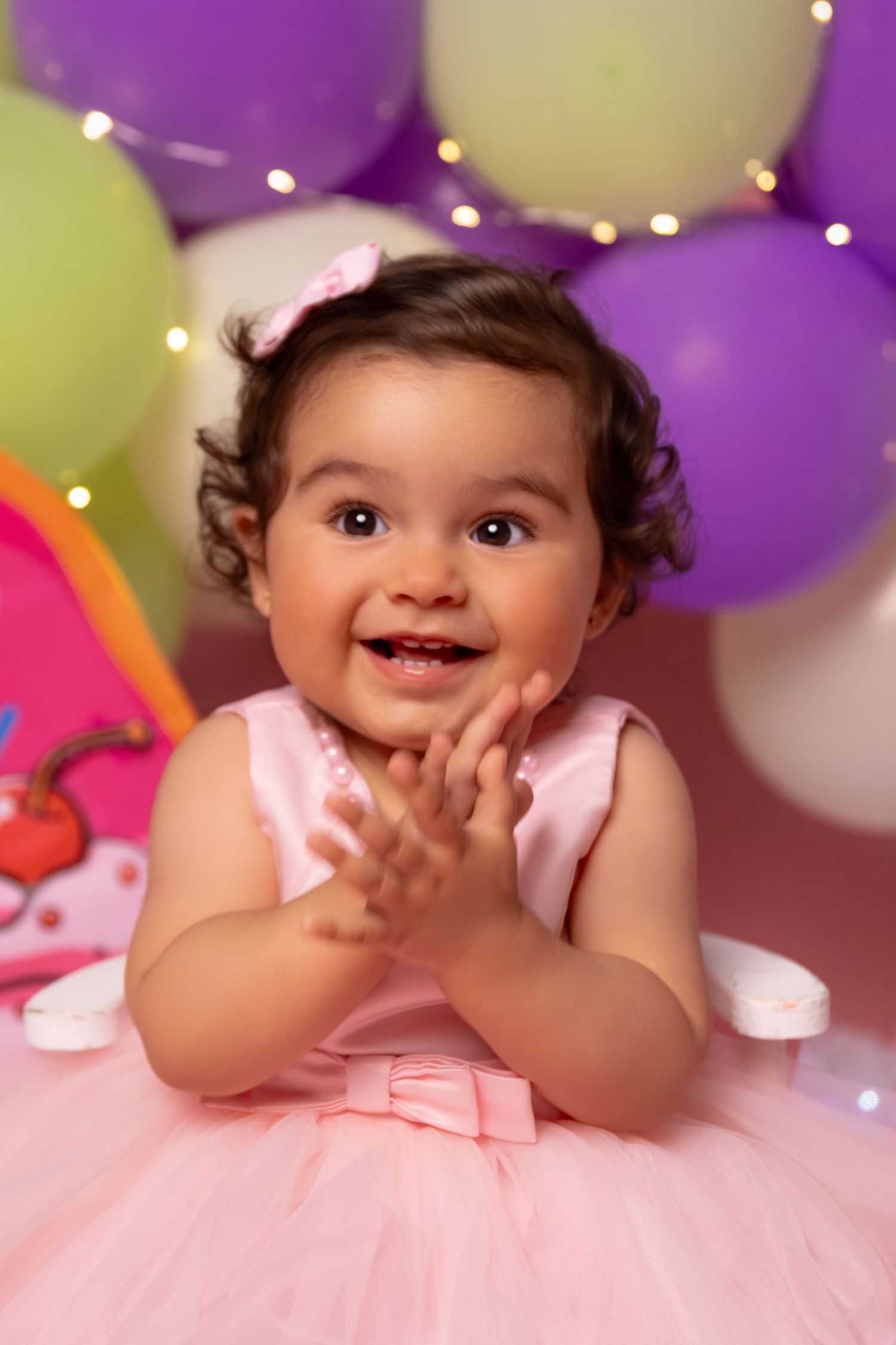 Joyful celebration scene with pink tulle dress and festive balloon decorations.