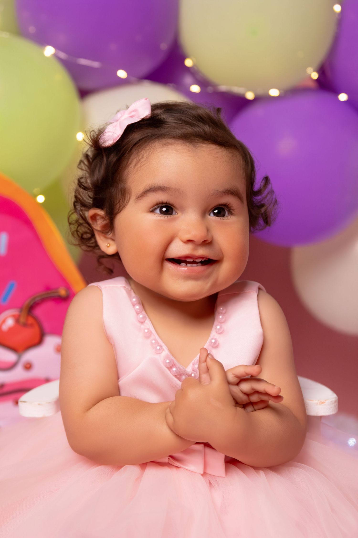 Sweet celebration scene with pink tulle dress and purple and yellow balloon decorations.