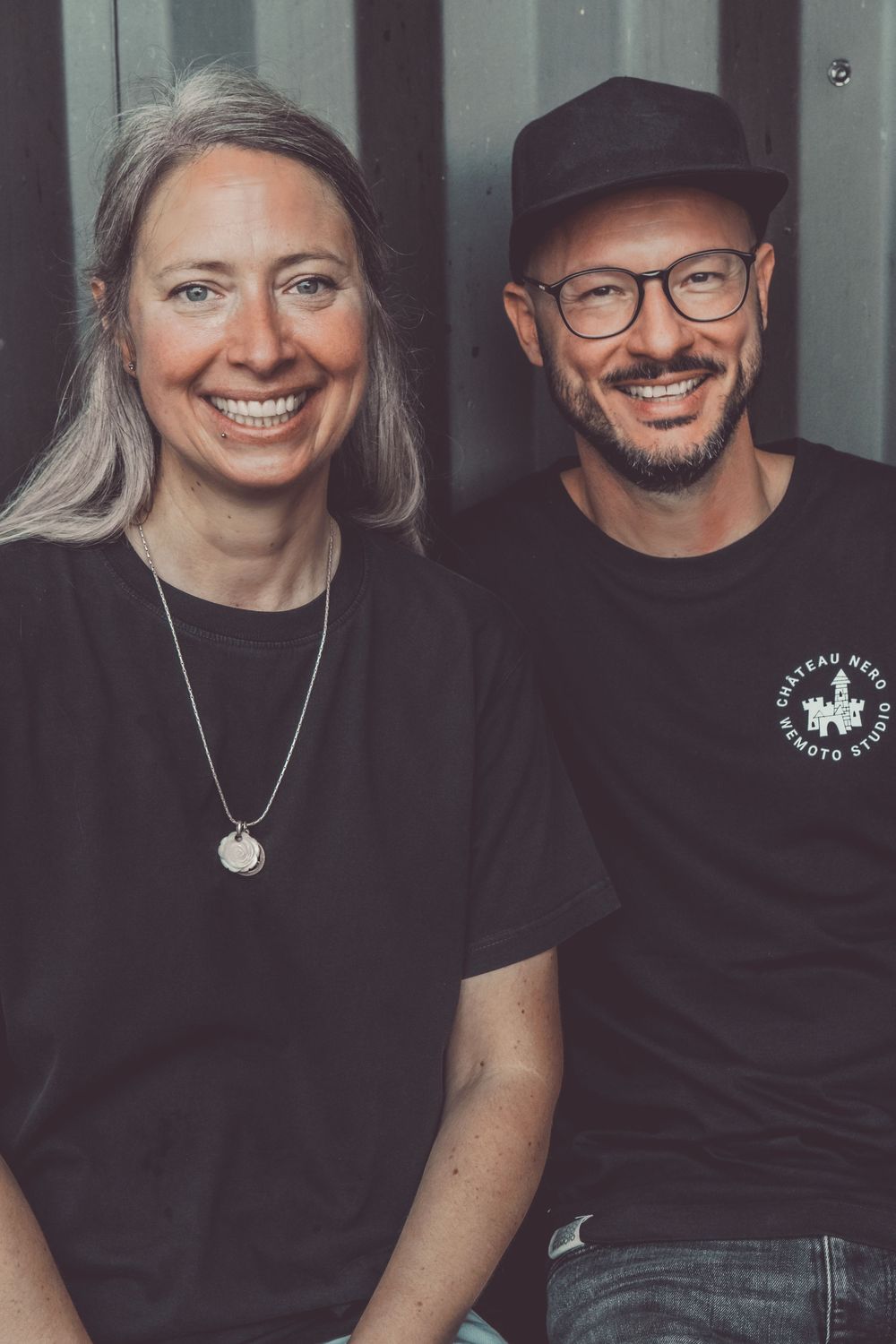 A couple wearing matching black t-shirts sit close together smiling in a series of candid photos.