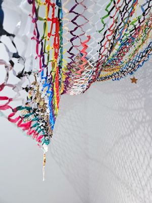 Colorful streamers and party decorations hang from a white ceiling in a festive zigzag pattern.