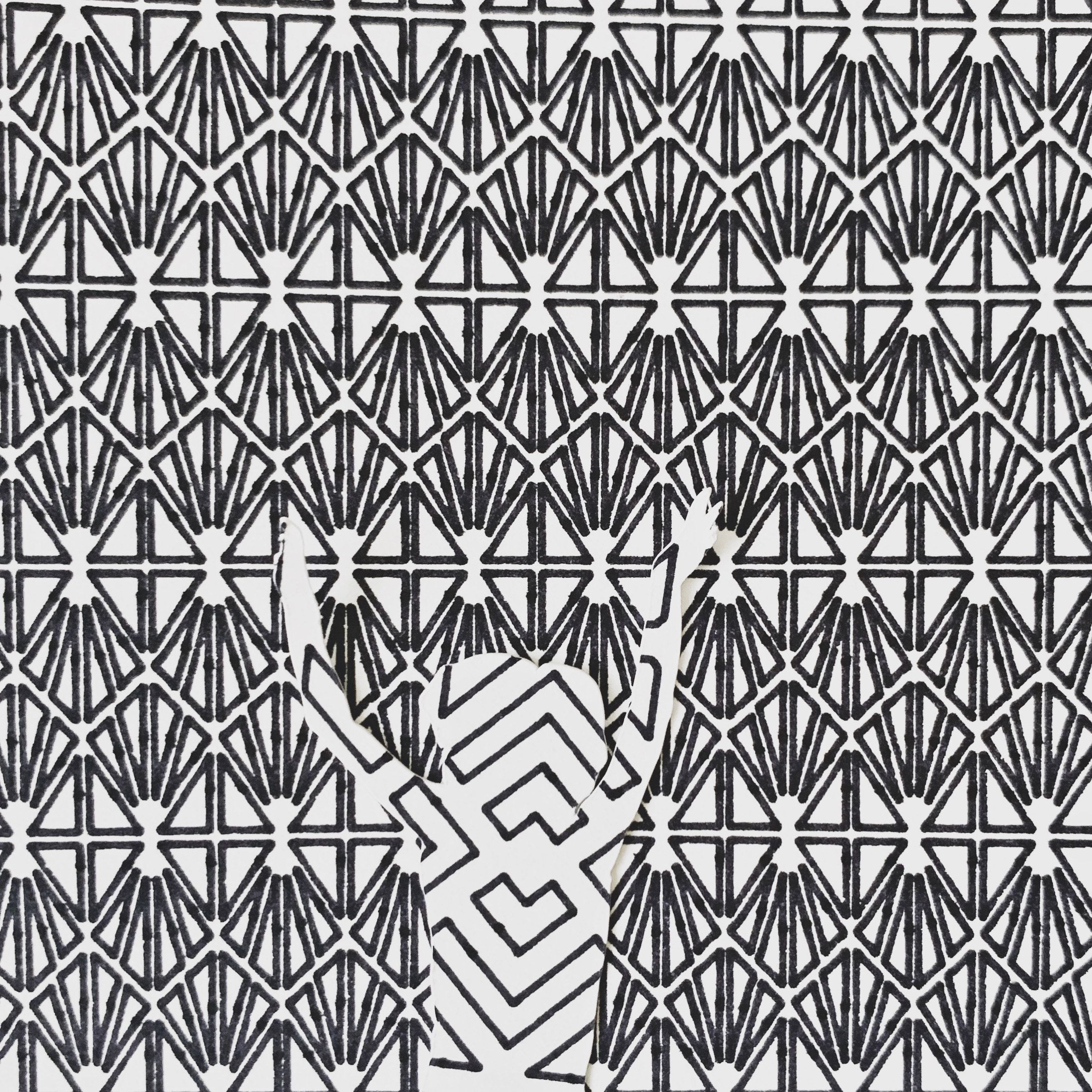 Black and white geometric pattern collage drawing with an abstract figure emerging from repeating shapes.
