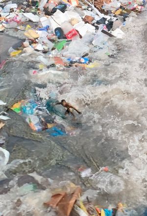 Photography of debris and plastic waste floating in turbulent water, highlighting environmental pollution.