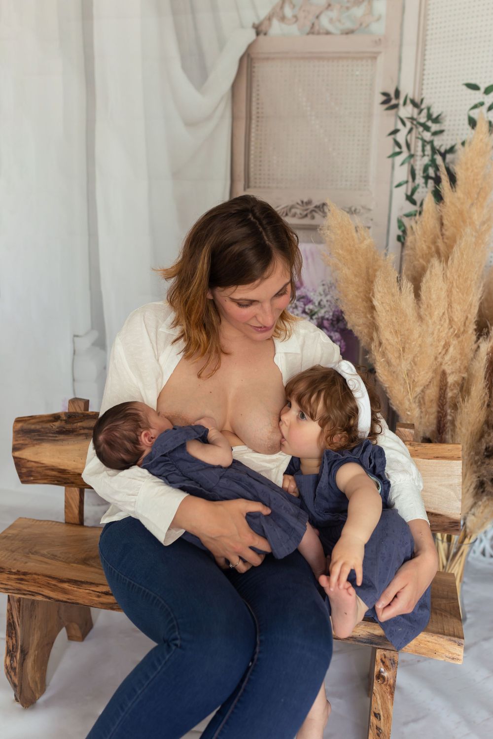 Séance photo allaitement en intérieur : maman allaitant ses deux enfants, photographie de maternité authentique et naturelle à Niort/