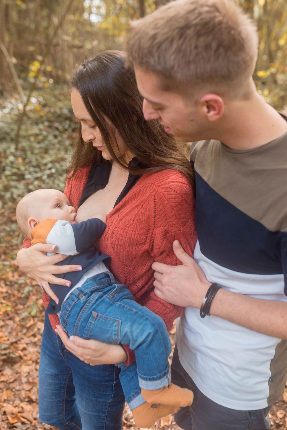 Famille en forêt lors d'un moment d'allaitement, portrait de couple avec bébé au cœur de la nature, séance photo lifestyle près de Niort.