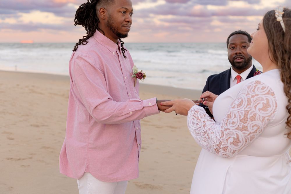 A beach wedding ceremony during sunset with exchange of rings.