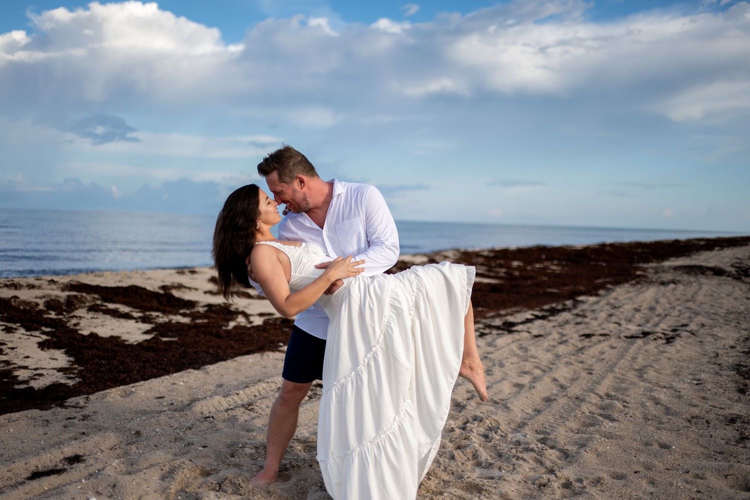 Romantic beach photoshoot sequence with couple embracing on sandy shoreline at sunset.