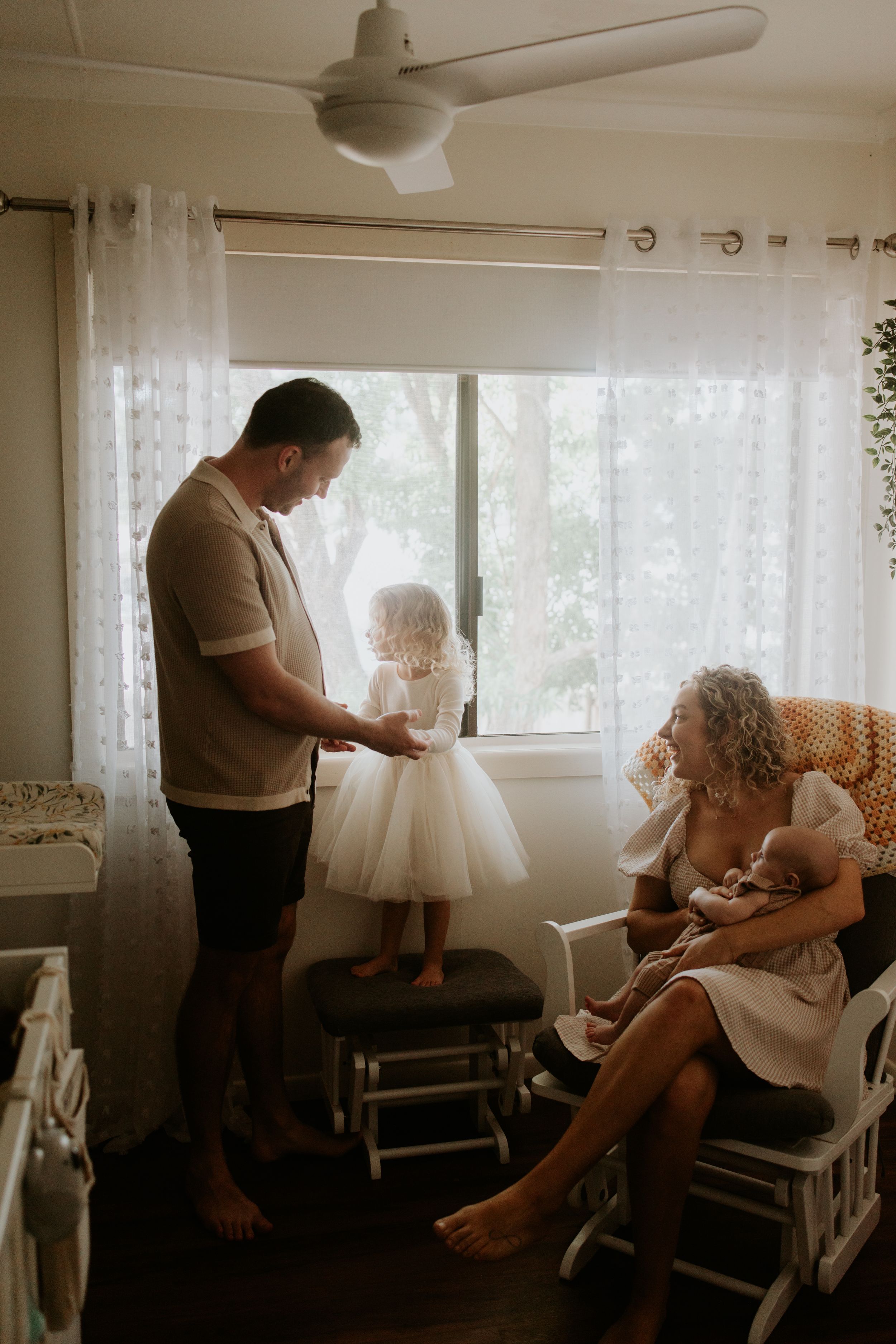 Candid black and white photos show tender moments between family members getting ready in a sunlit room.