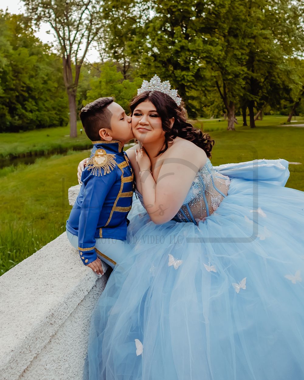 A heartwarming moment between a child in a royal blue uniform and someone in a butterfly-adorned blue ballgown.