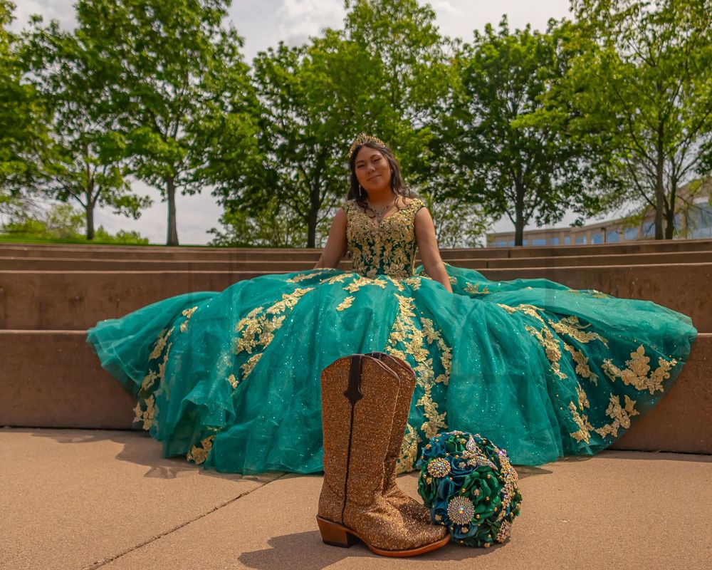 A western-inspired quinceañera photo featuring a turquoise ballgown and cowboy boots.