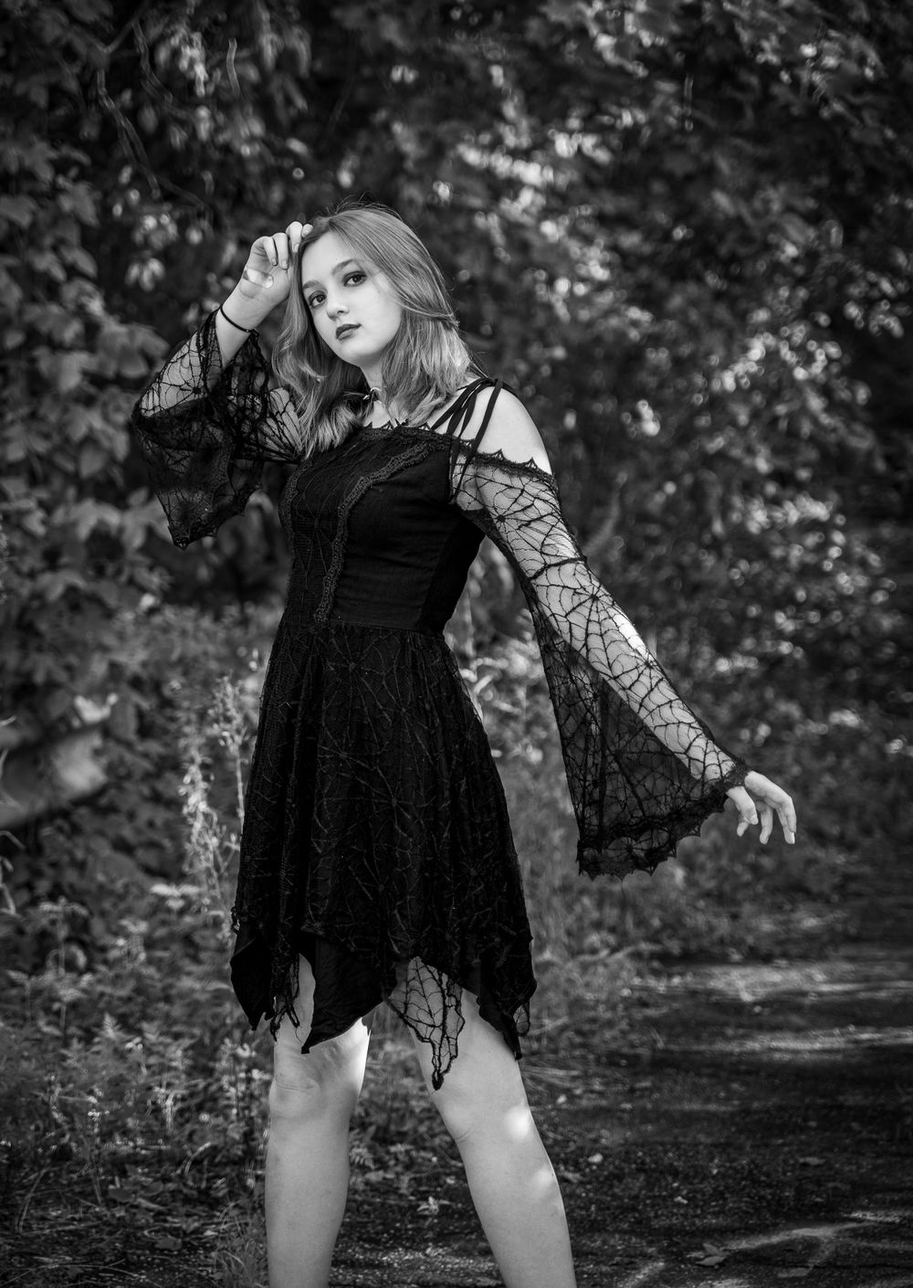 Teen girl in pretty dress with a wooded background in black and white at Cry Baby Bridge, Anderson, South Carolina.