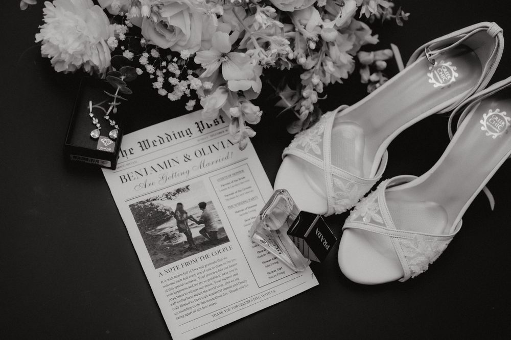 Wedding shoes and floral details arranged with a newspaper announcement in black and white.
